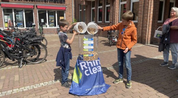 Kinderen stoppen de gevonden sigarettenpeuken tijdens de Rhine Clean Up op 8 mei in de bak